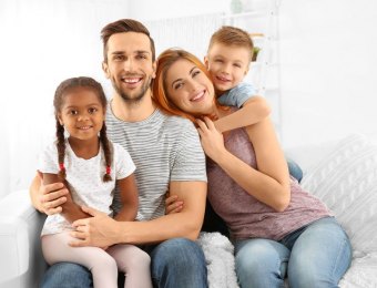 Happy interracial family sitting on sofa